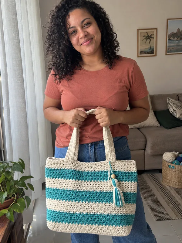 Mulher com bolsa de crochê em casa