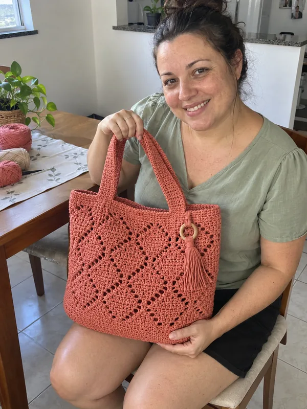 Mulher com bolsa de crochê em casa