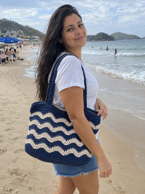Mulher com bolsa de crochê na praia