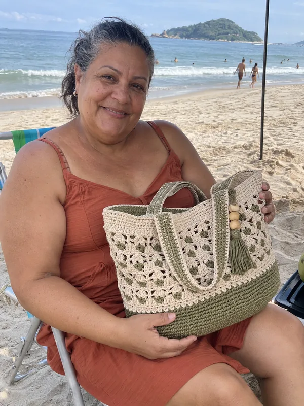 Mulher com bolsa de crochê na praia